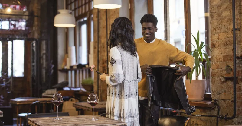 A couple enjoying a romantic date in a cozy café setting, exchanging smiles.