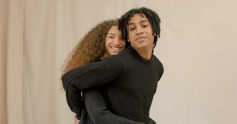 Happy couple bonding in a cozy setting, embracing and smiling warmly.