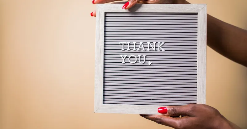 Close-up of hands holding a thank you sign, perfect for expressing gratitude.