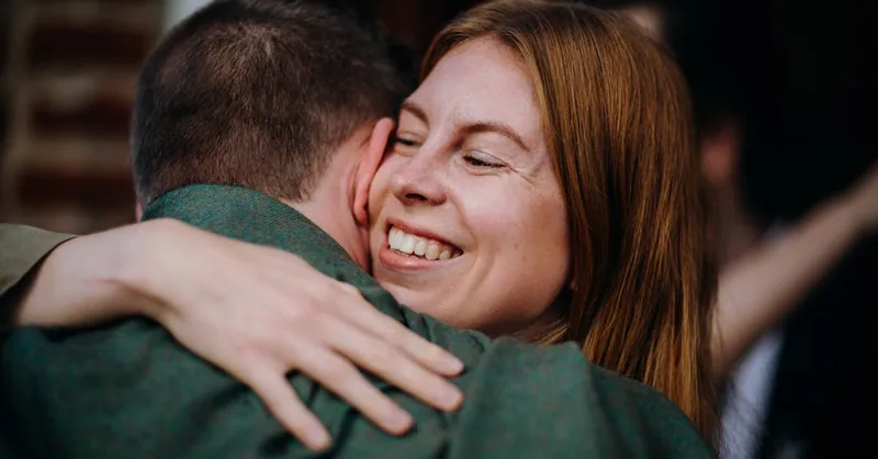 A woman joyfully embracing a man, expressing happiness and warmth.