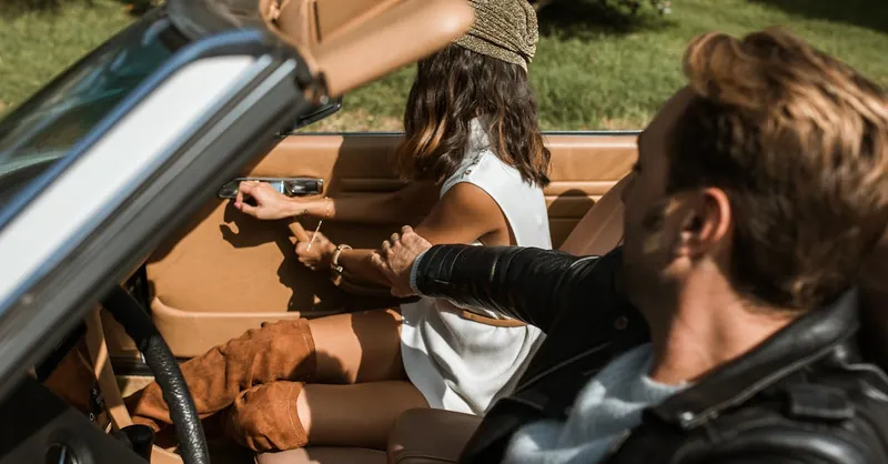 A couple having an argument in a convertible car during a summer day outdoors.