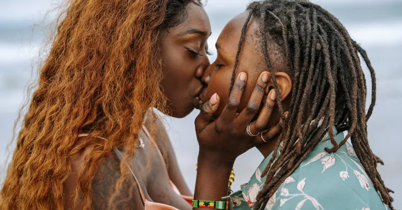 Intimate close-up of a loving couple sharing a kiss by the ocean. Captures affection and connection.
