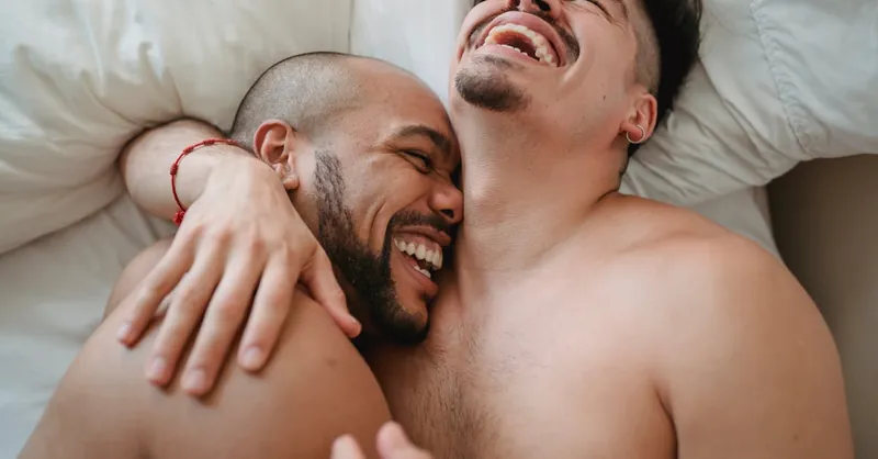 Loving and joyful moment between an affectionate couple relaxing and laughing together indoors.