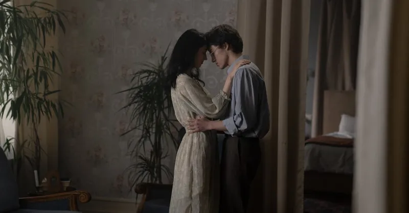 A romantic couple sharing an intimate moment in a cozy indoor setting.