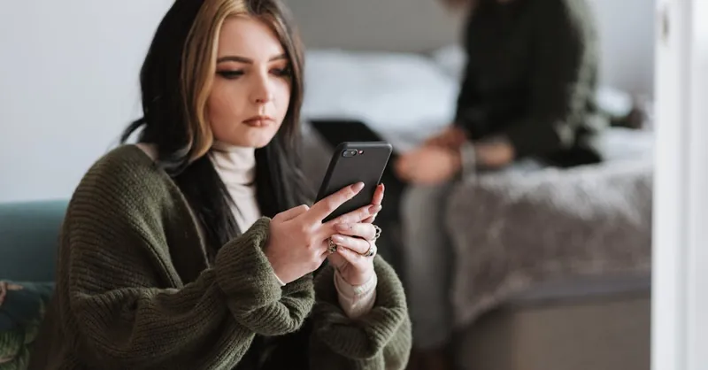 A young couple focused on their smartphones, highlighting modern communication and relationship dynamics.