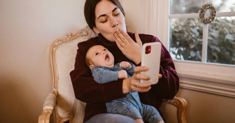 A mother and baby enjoy a video call indoors, capturing a tender moment of connection and warmth.