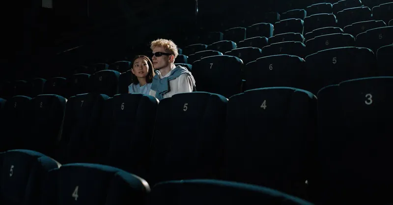 A couple enjoying a private movie screening in an empty theater setting, creating an intimate atmosphere.