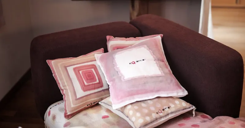 A cozy indoor scene featuring a modern sofa adorned with stylish pink and beige cushions.