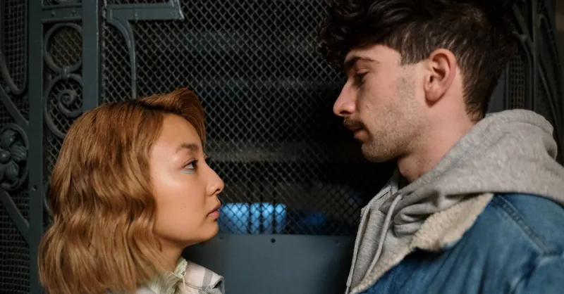 A young couple looking at each other intently, conveying romantic connection indoors.