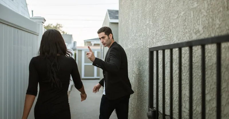 A couple having a tense argument in an outdoor alley, showcasing relationship conflict.
