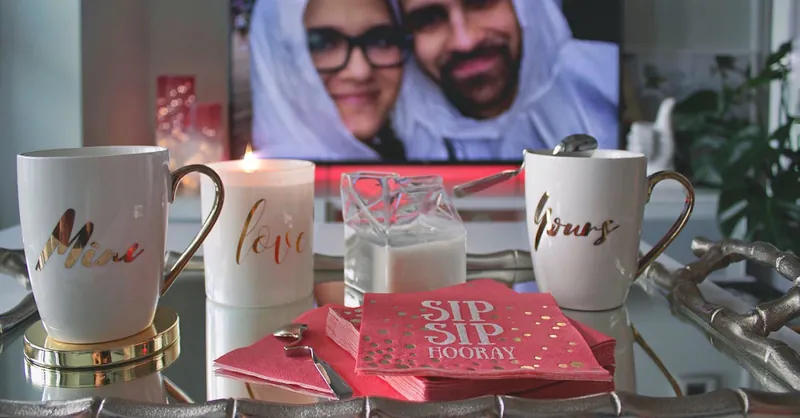 Cozy setting with personalized mugs, candle, and couple