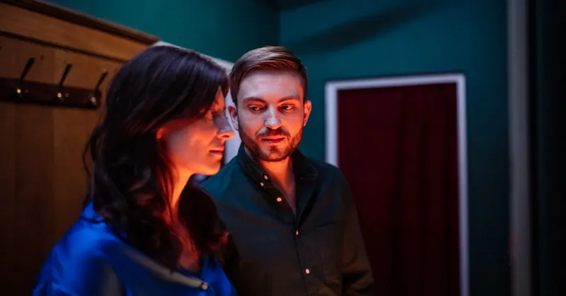 A close-up shot of a couple sharing a moment indoors, with ambient lighting and warm atmosphere.