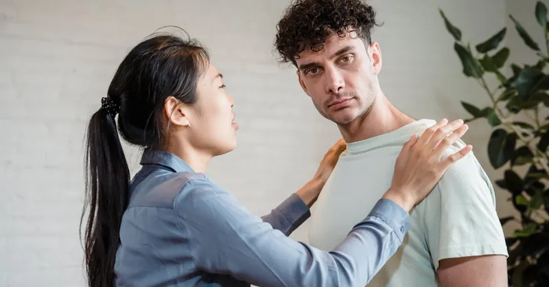 Man and woman engaging in a serious discussion indoors, expressing emotions.